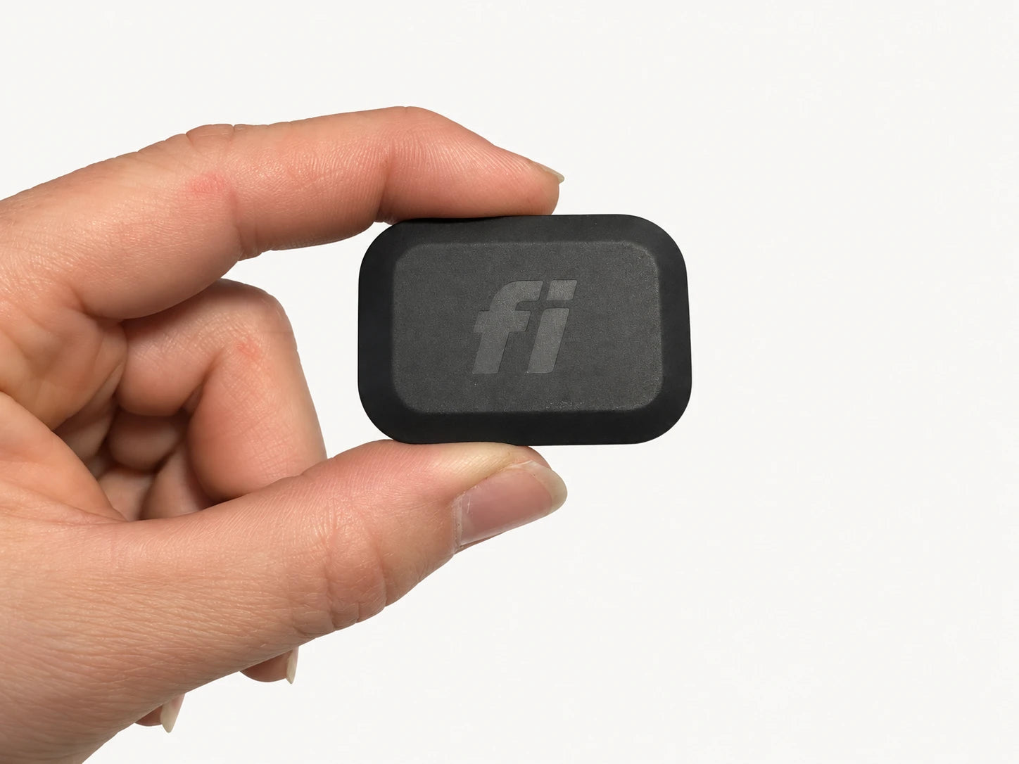 Fi Mini tracker held between fingers