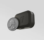 Fi Mini tracker shown with a quarter for scale