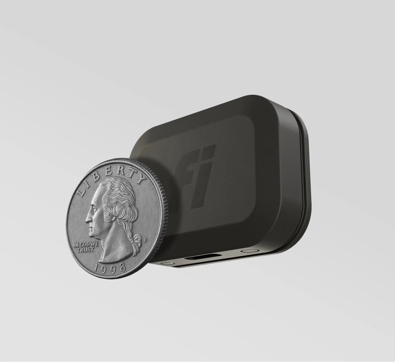 Fi Mini tracker shown with a quarter for scale